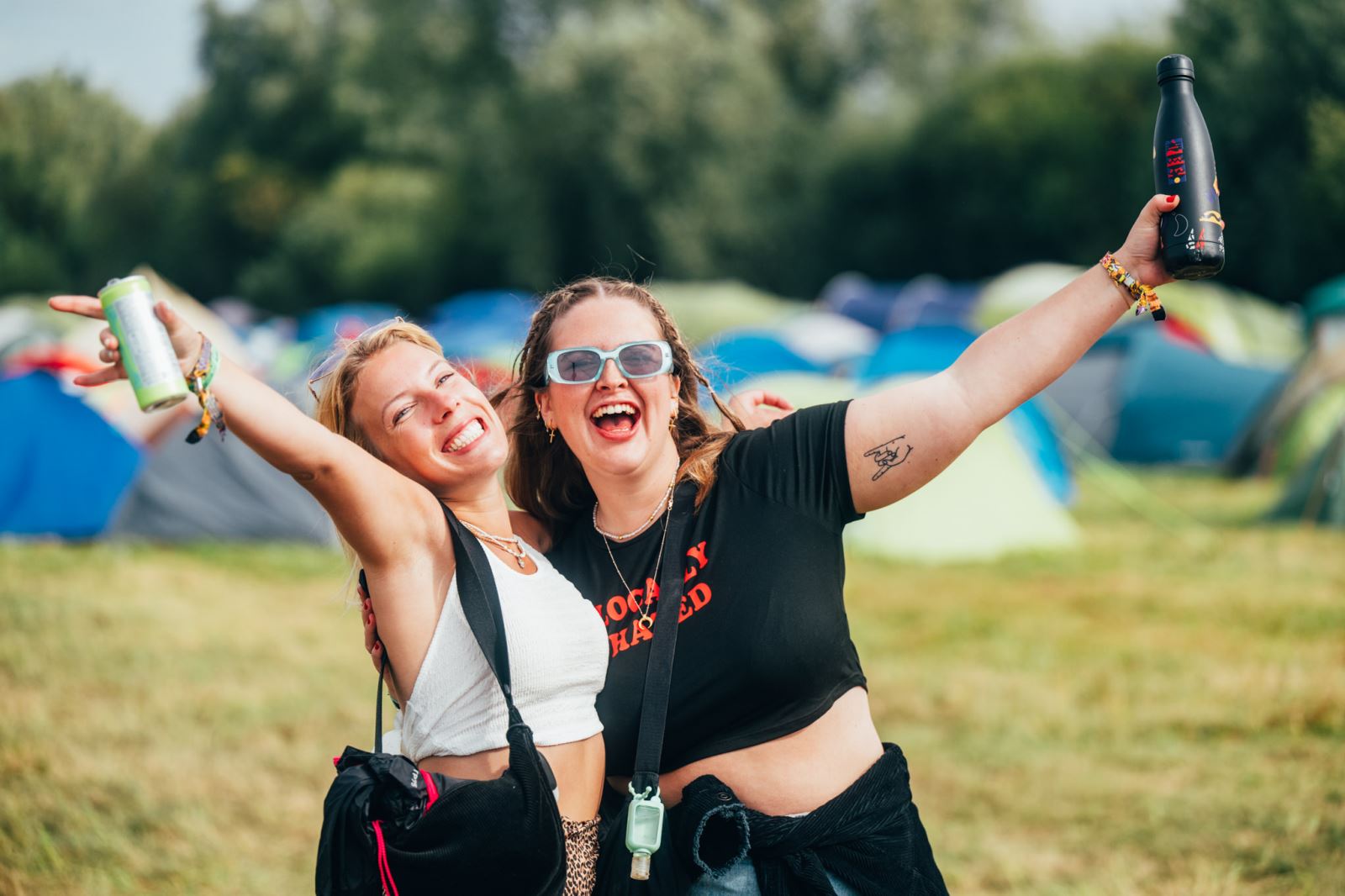 Two girls posing in front of tents